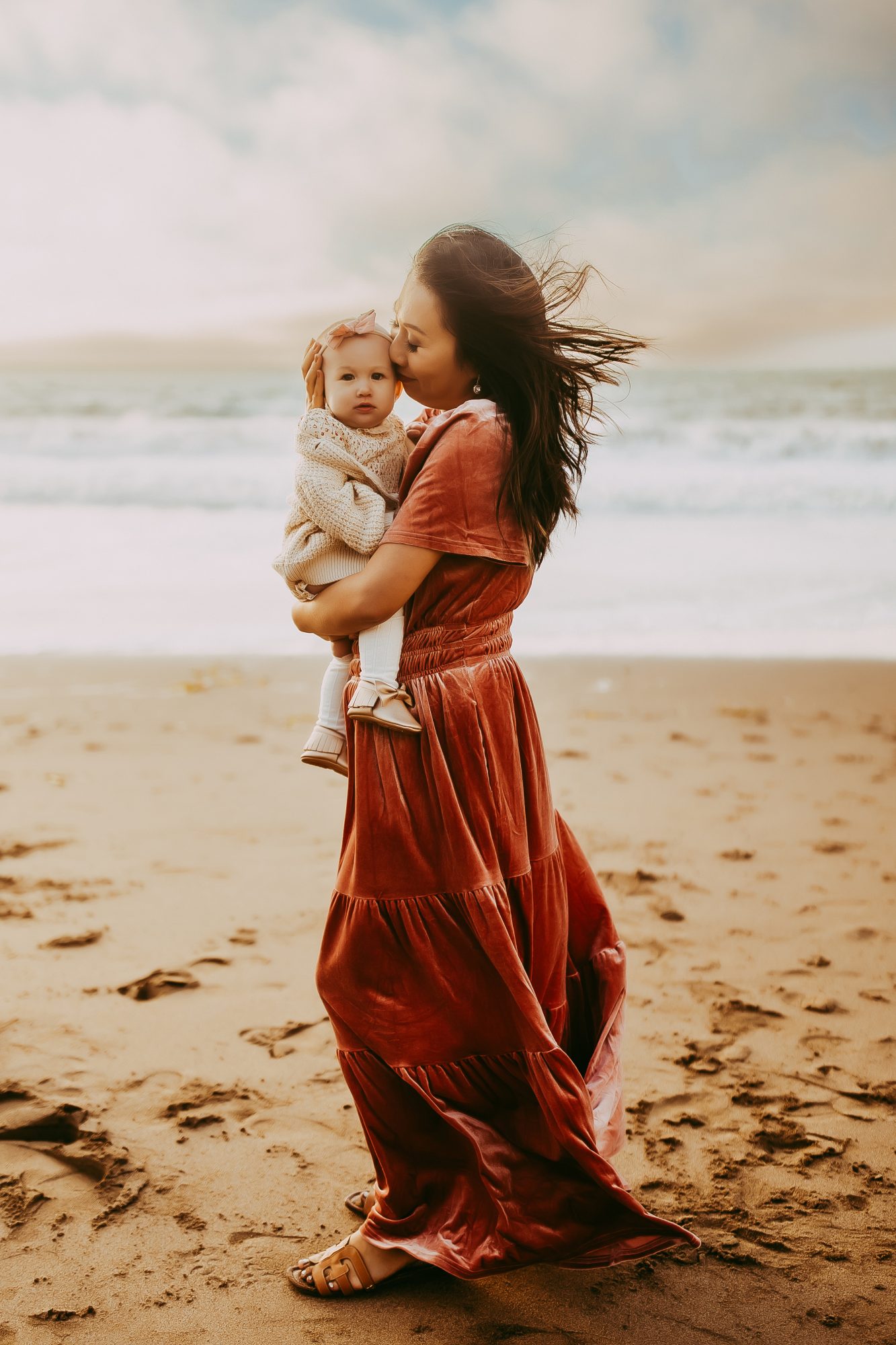 Shefali Parekh | Capturing Joy and Laughter: The Family Session at Baker Beach A mother cradling her child