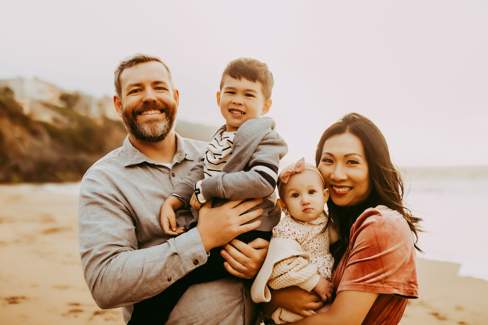 Shefali Parekh | Capturing Joy and Laughter: The Family Session at Baker Beach A family smiling and posing together for a photo