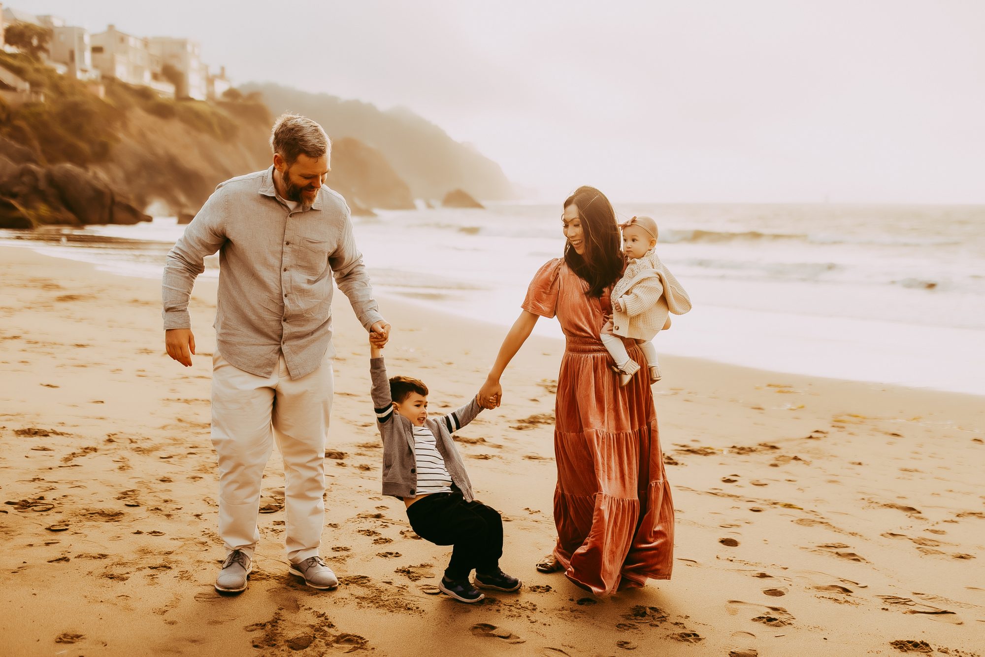 Shefali Parekh | Capturing Joy and Laughter: The Family Session at Baker Beach A family walks hand in hand on the beach