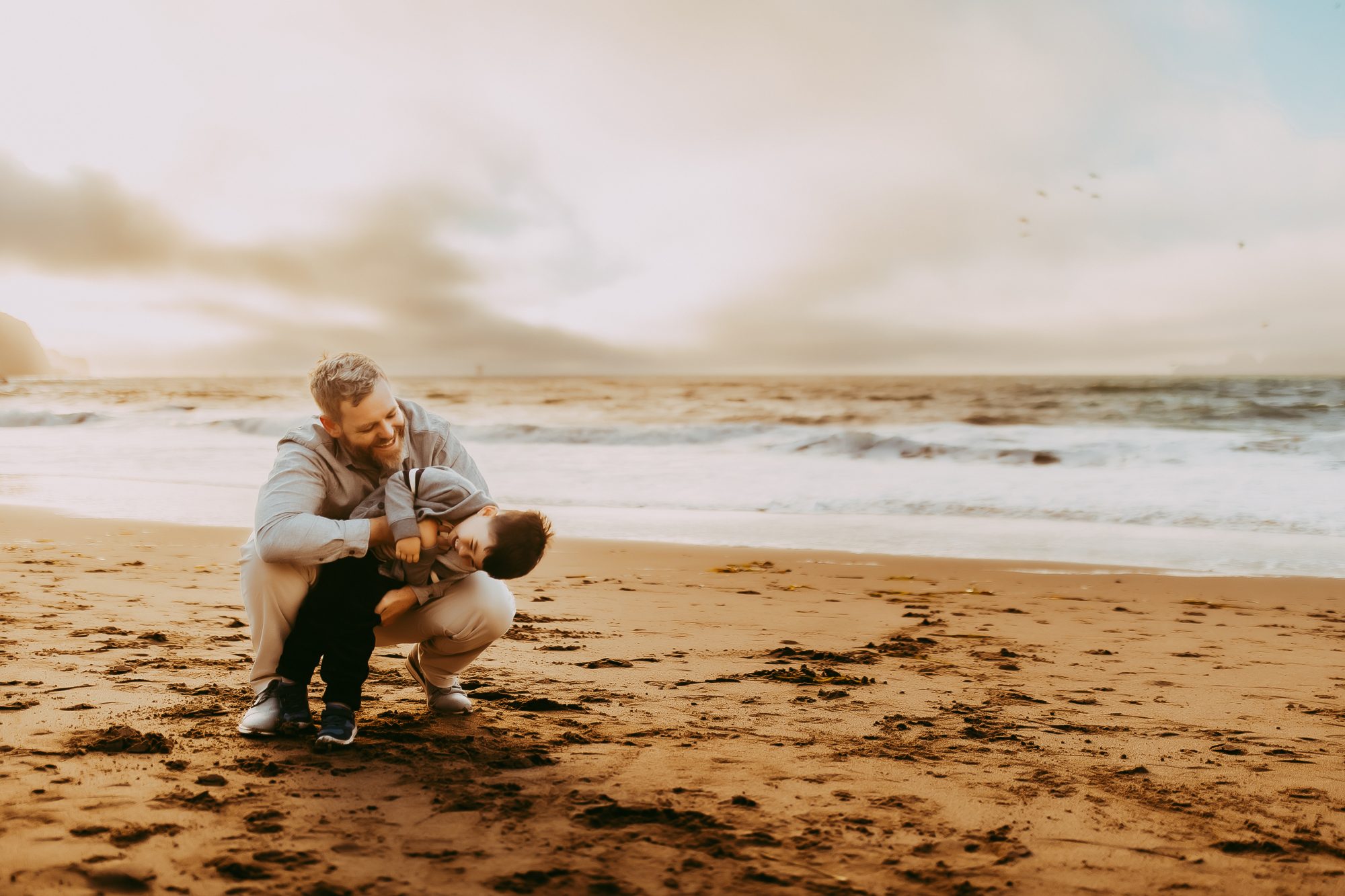 Shefali Parekh | Capturing Joy and Laughter: The Family Session at Baker Beach Father and son savoring a serene beach sunset