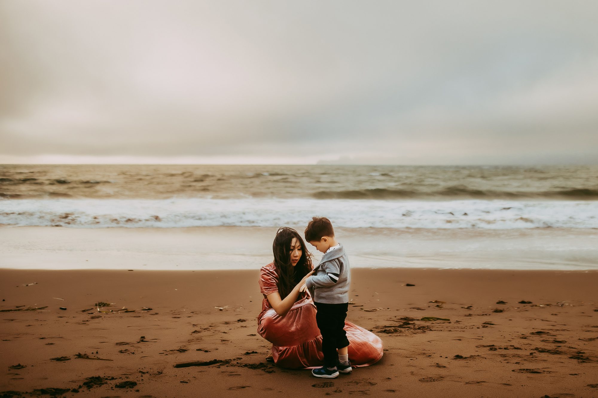 Shefali Parekh | Capturing Joy and Laughter: The Family Session at Baker Beach A woman and child enjoying a sunny day at the beach
