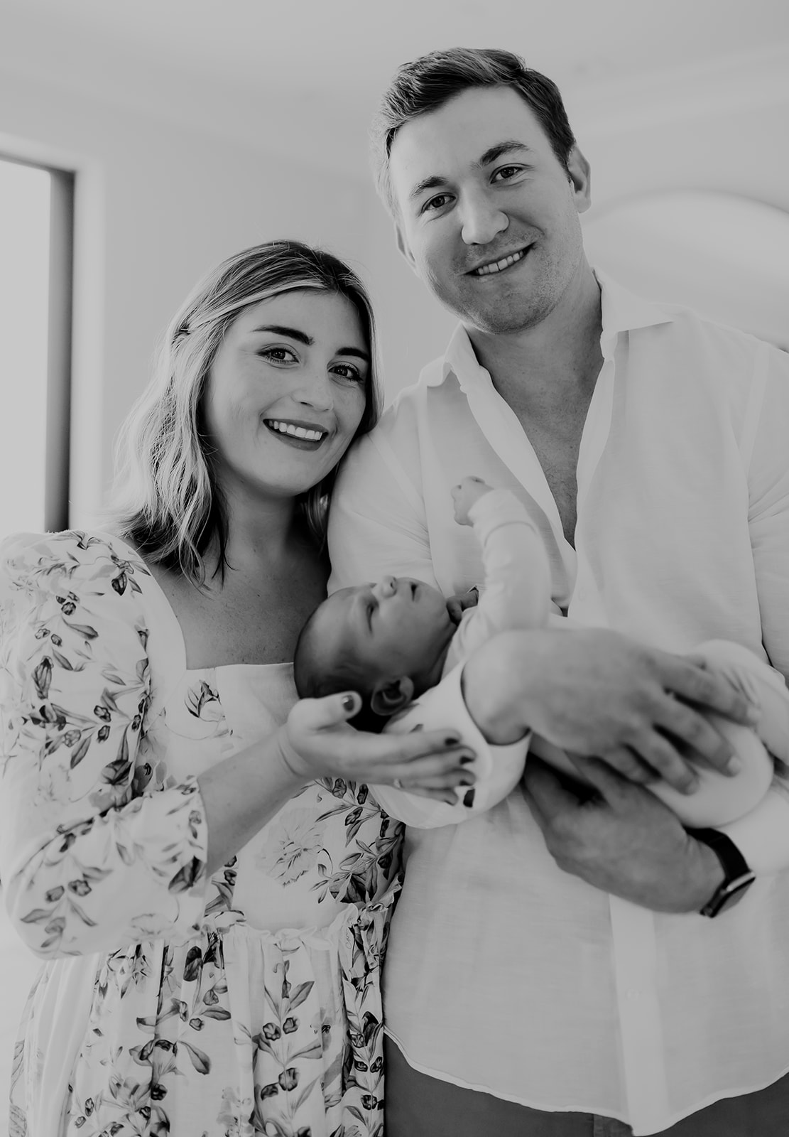 Shefali Parekh | Heartwarming In-Home Newborn Session: Maggie & Alex Black in Cow Hollow, San Francisco Couple posing with their newborn in black & white background