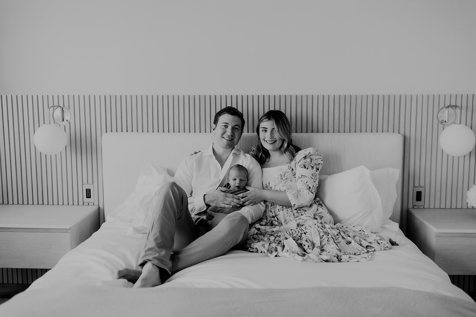 Shefali Parekh | Heartwarming In-Home Newborn Session: Maggie & Alex Black in Cow Hollow, San Francisco Couple sitting on bed holding their newborn