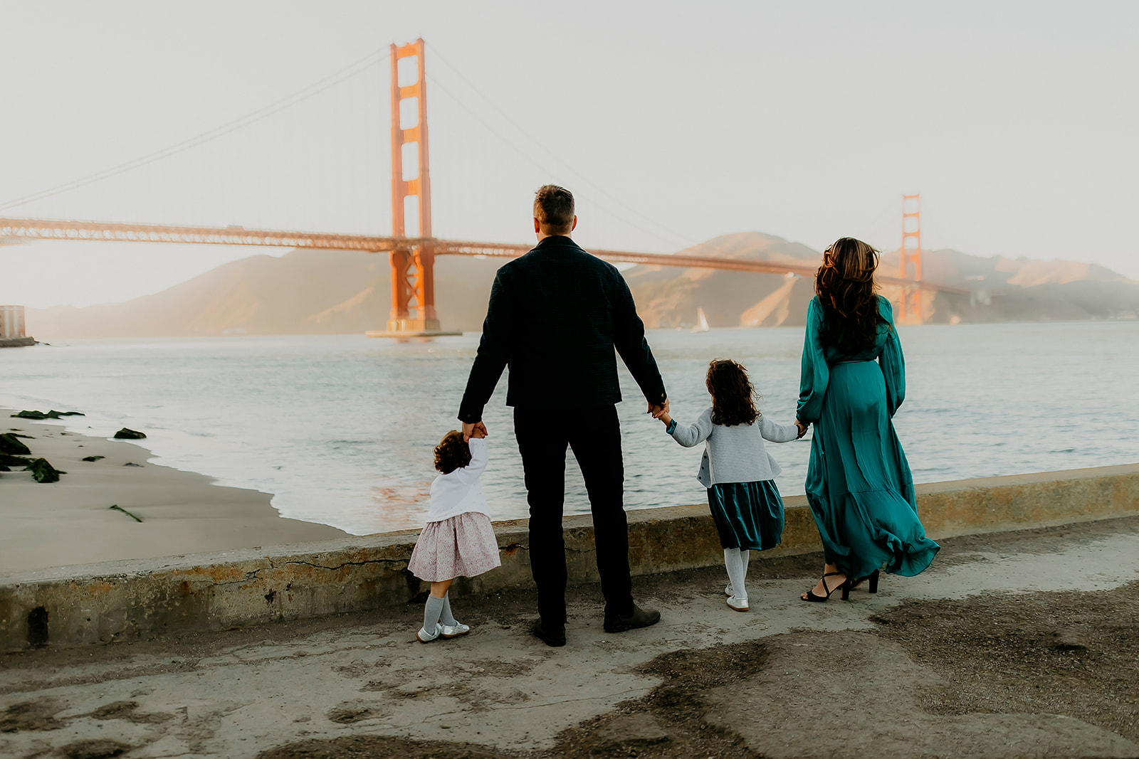 Shefali Parekh | The Best Location for Family Photography: Crissy Field Family posing looking towards golden gate bridge