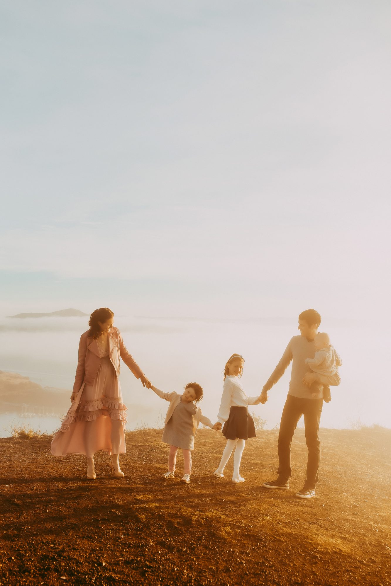 Shefali Parekh | Sunrise Family Photography in Marin County: Capturing Magic in the Morning Family posing hands in hands. San Francisco foggy photoshoot.