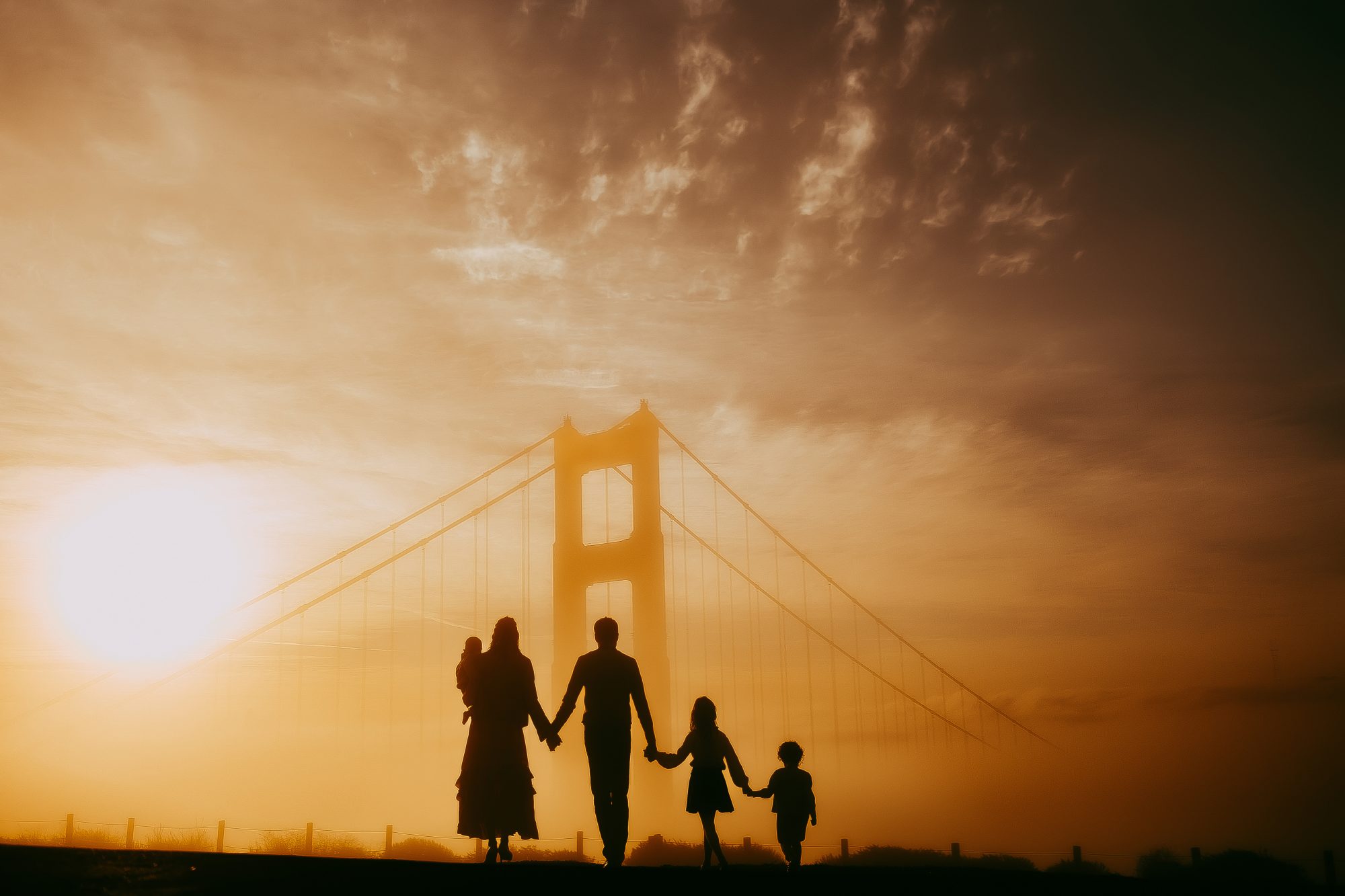 Shefali Parekh | Sunrise Family Photography in Marin County: Capturing Magic in the Morning Shadow picture of a family of five with the golden gate bridge. Battery Spencer, San Francisco.