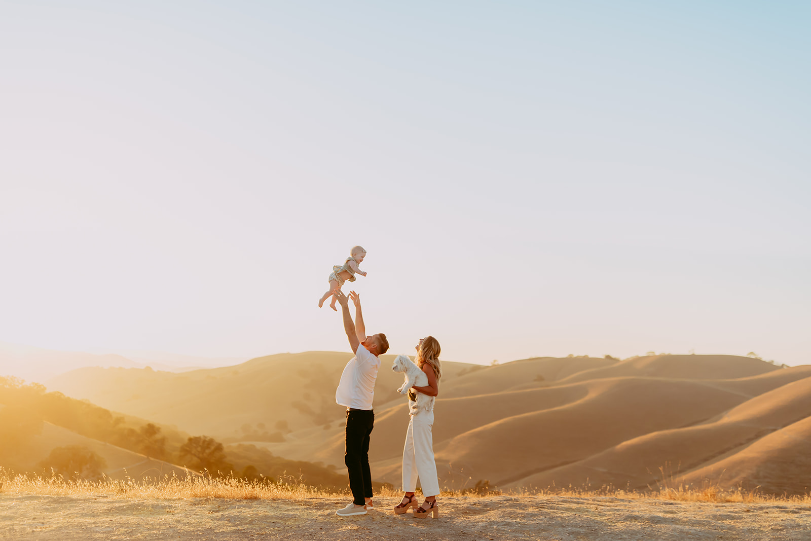 Shefali Parekh | Creating Your Family's Visual Story | Bay Area Photographer Tips Shefali Parekh, Bay Area family photographer, capturing a family of three at sunset in a field overlooking hills