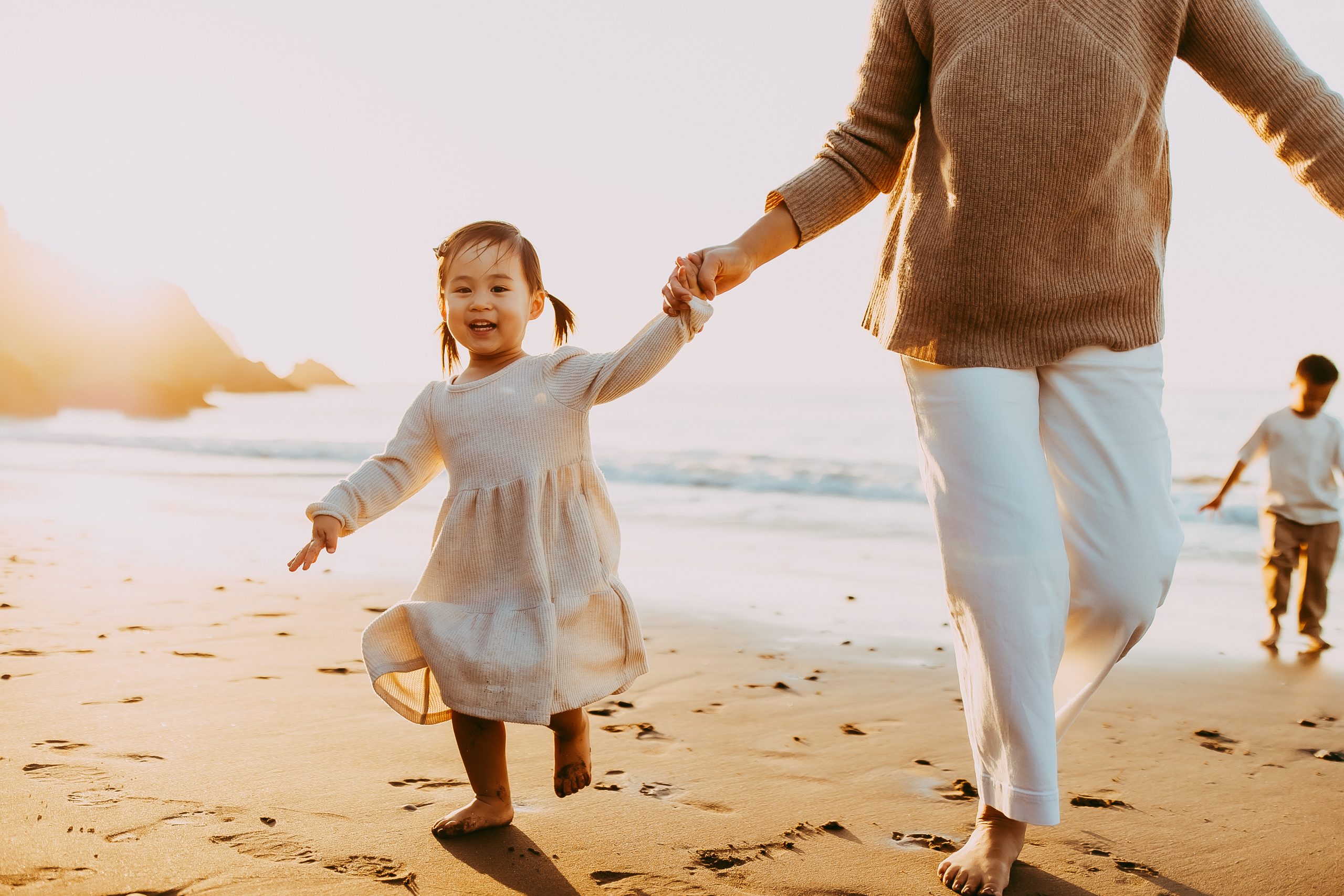 Shefali Parekh | Bay Area Beach Family Photoshoot Tips Parents holding hands with their children during a scenic beach photoshoot