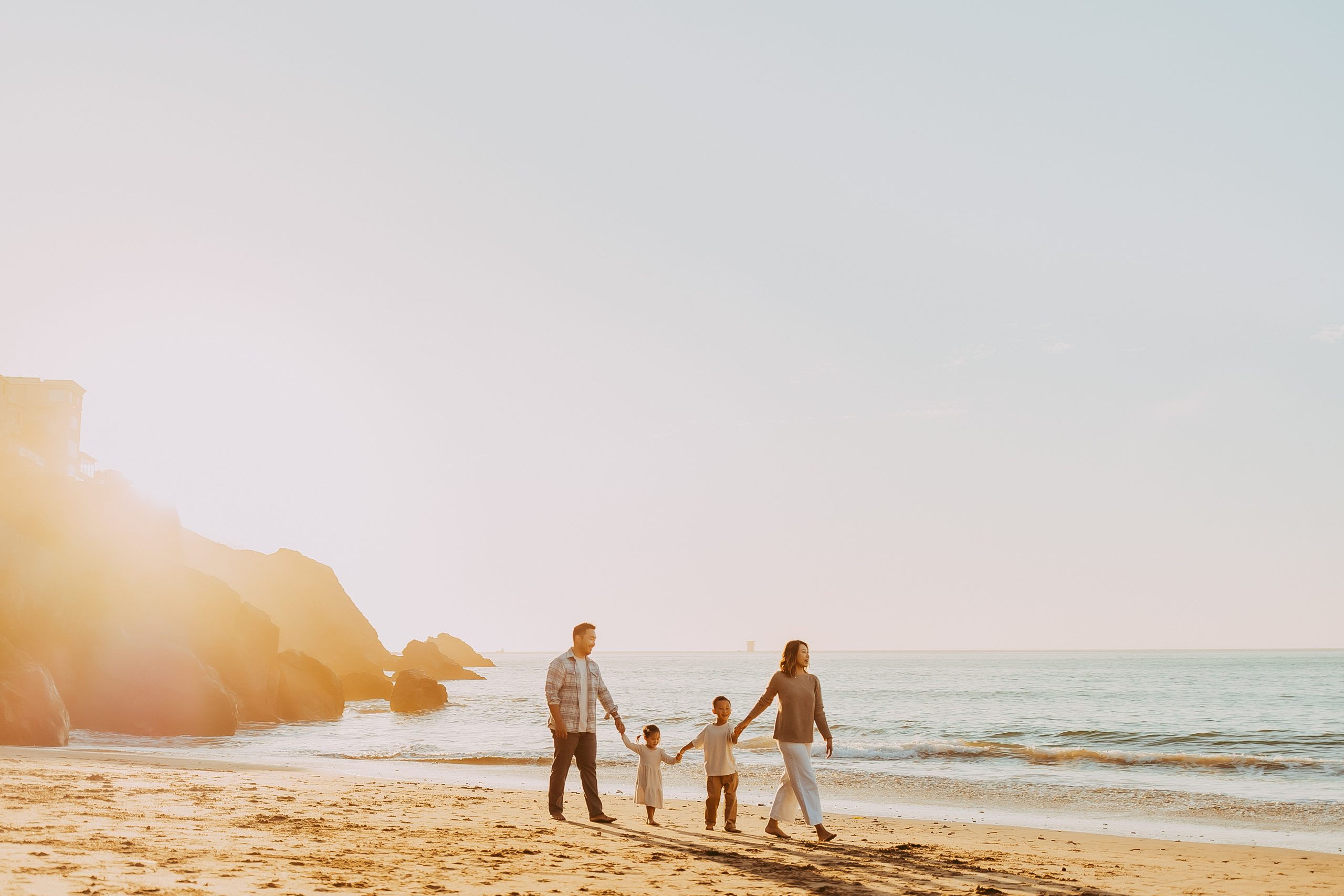 Shefali Parekh | Bay Area Beach Family Photoshoot Tips Parents and children walking along the shoreline in the Bay Area.