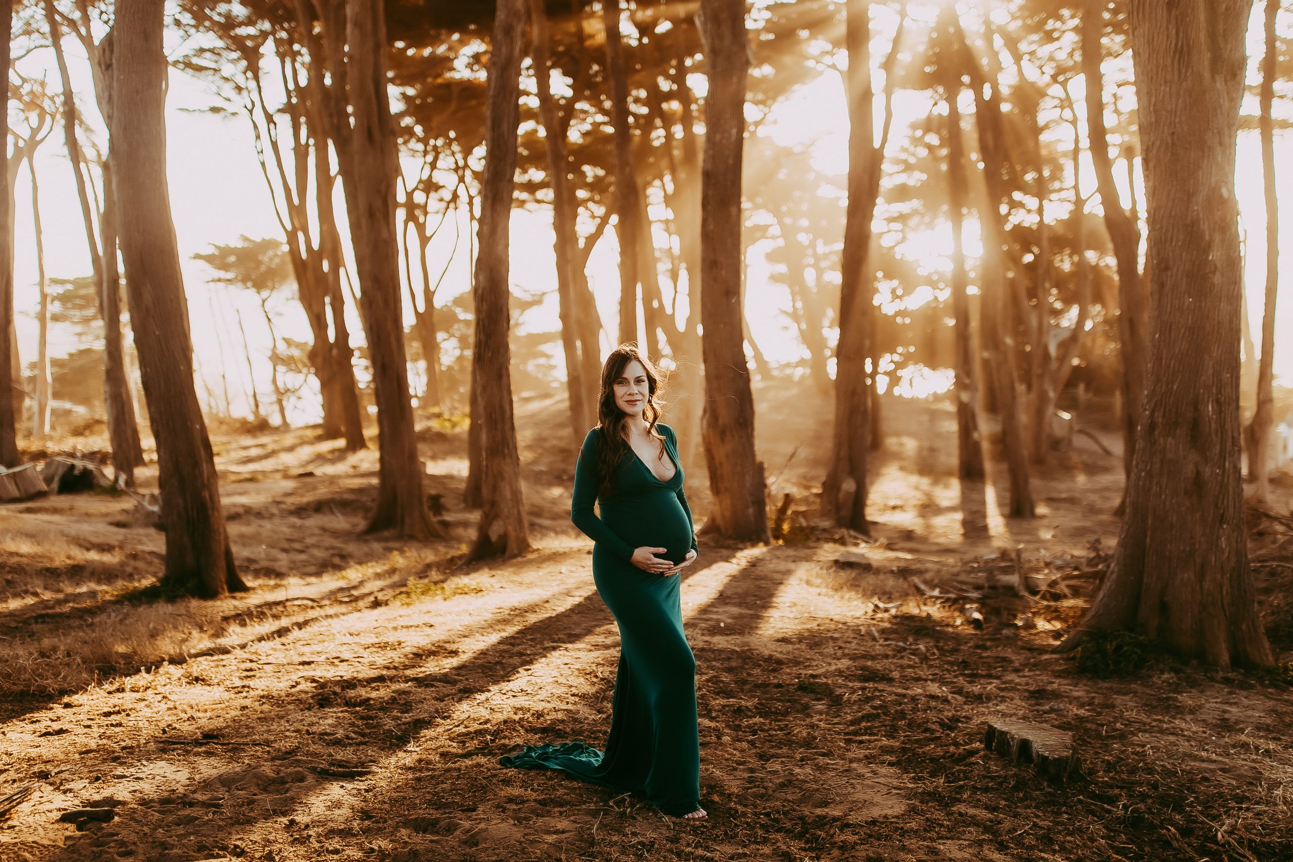 Radiant pregnant woman posing in golden hour light at Sutro Baths