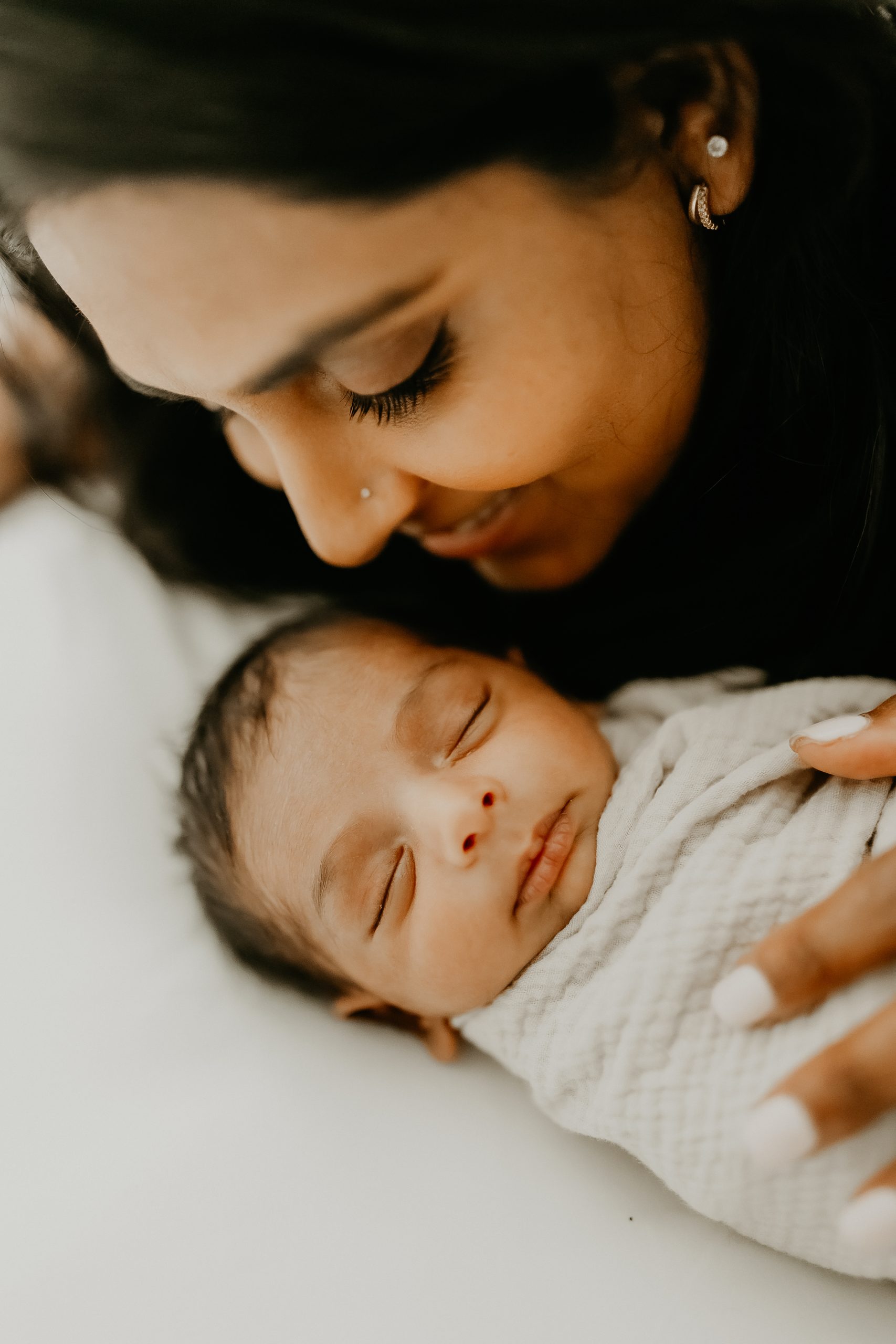 Shefali Parekh | Newborn Photography Trends in San Francisco: What's Popular in 2025 Mother tenderly holding her newborn baby during a lifestyle newborn photography session in Bay Area California