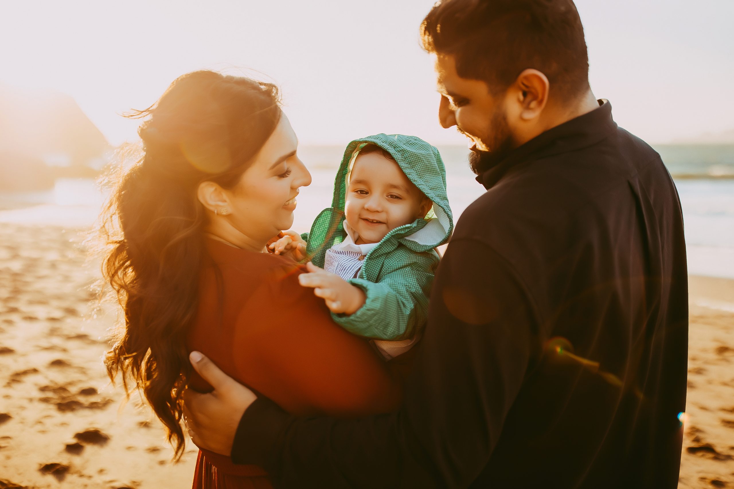 Shefali Parekh | The Best Time for a Baker Beach Photoshoot family of three embracing on the beach in san francisco