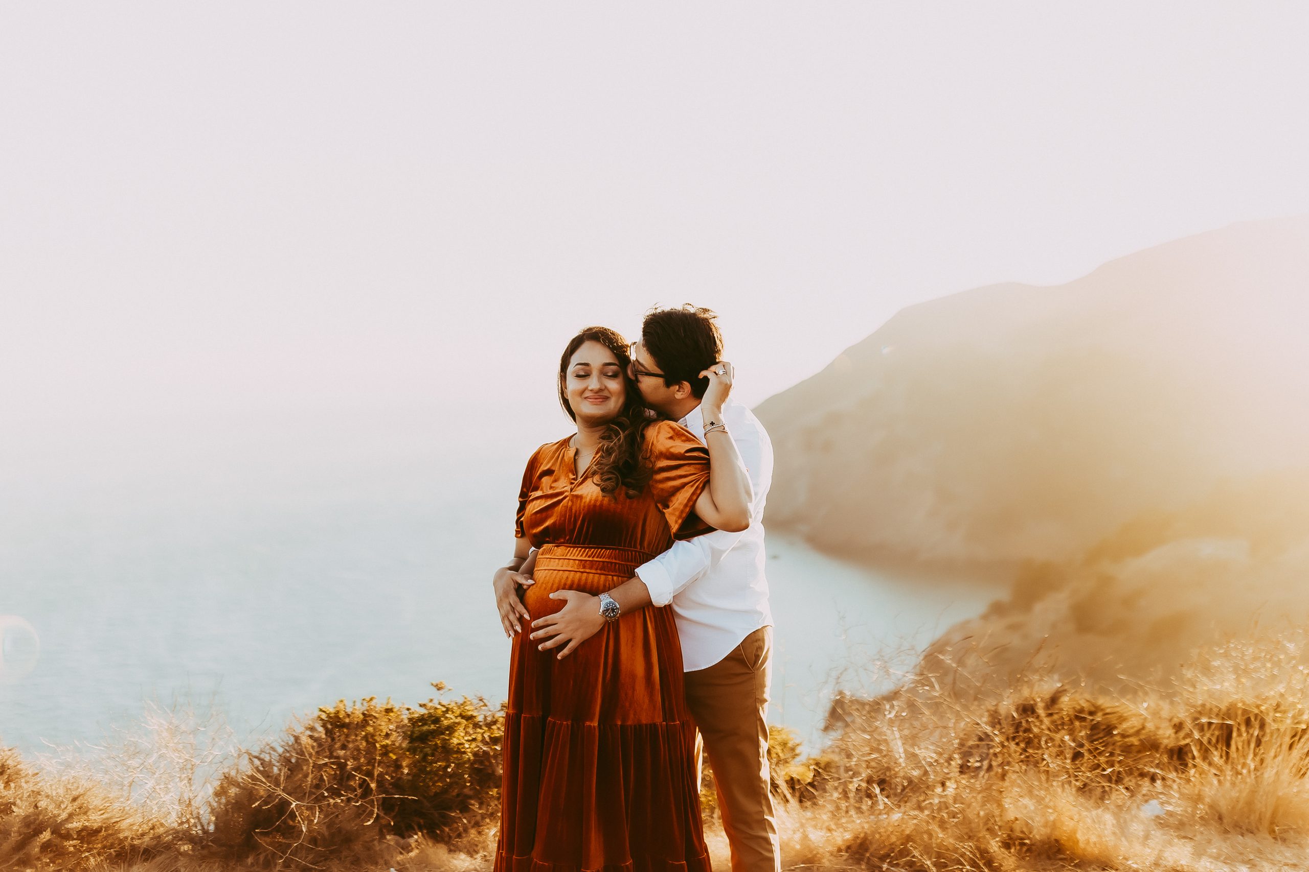 Shefali Parekh | Picnic Gender Reveal | Marin County Maternity Photographer Expecting parents embracing on hillside during Marin Headlands maternity photography session